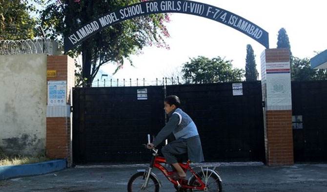 Seorang anak laki-laki bersepeda melewati sekolah yang tutup di Islamabad, Pakistan, pada 26 November 2020. Pakistan menutup lembaga pendidikan hingga 10 Januari tahun depan menyusul lonjakan kasus COVID-19. (Xinhua/Ahmad Kamal)