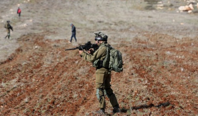 Seorang tentara Israel membidikkan senapannya ke arah pengunjuk rasa Palestina dalam bentrokan menyusul aksi protes menentang perluasan permukiman Yahudi di Desa Beit Dajan di sebelah timur Nablus, Tepi Barat, pada 4 Desember 2020. (Xinhua/Ayman Nobani)
