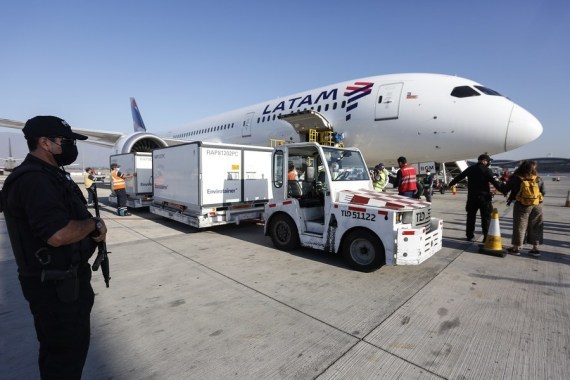 Para pekerja memindahkan kontainer berisi pengiriman keempat vaksin COVID-19 yang dikembangkan oleh perusahaan China Sinovac di bandara internasional Santiago di Santiago, Chile, pada 26 Februari 2021. (Xinhua)