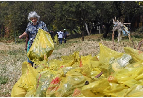 Seorang sukarelawan meletakkan sampah yang terkumpul di tempat yang telah ditentukan di Pretoria, Afrika Selatan (Xinhua/Chen Cheng)