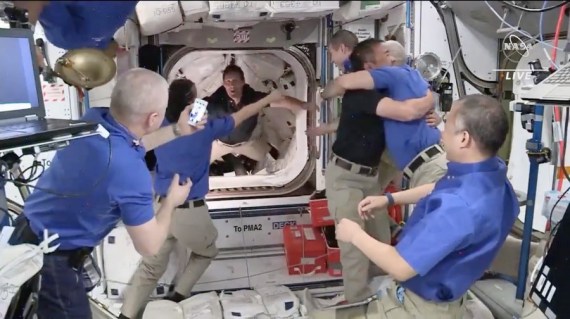 Tangkapan layar dari video yang diabadikan pada 24 April 2021 ini menunjukkan momen para astronaut awak Crew Dragon SpaceX disambut dengan pelukan oleh anggota kru di Stasiun Luar Angkasa Internasional. (Kredit: NASA)