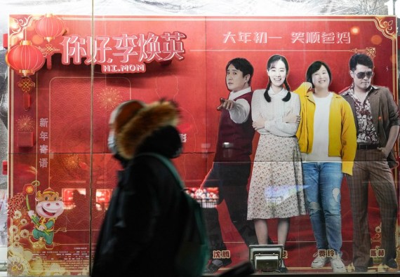 Para pejalan kaki melewati poster film komedi "Hi, Mom" di Beijing, ibu kota China, pada 17 Februari 2021. (Xinhua/Chen Zhonghao)