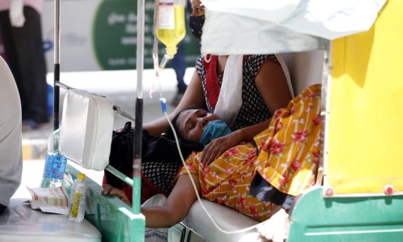 Seorang pasien positif COVID-19 mendapatkan perawatan dasar di dalam becak motor saat menunggu giliran masuk ke sebuah rumah sakit di Ahmedabad, India, pada 26 April 2021. (Xinhua/Str)