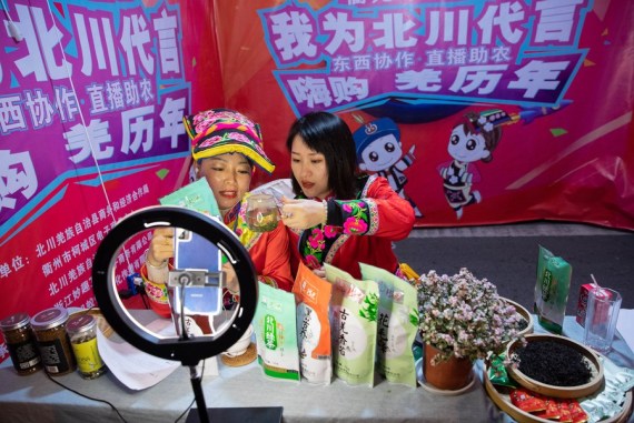Para petani yang mengenakan kostum etnis Qiang menjual produk lokal melalui siaran langsung daring (livestream) di wilayah Beichuan, Provinsi Sichuan, China barat daya, pada 14 November 2020. (Xinhua/Jiang Hongjing)