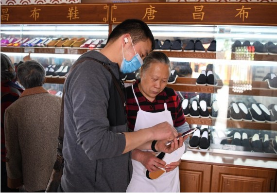Lai Shufang (kanan) memeriksa pembayaran seorang pelanggan di Desa Zhanqi, sebuah desa yang terletak di Tangchang, Chengdu, Provinsi Sichuan, China barat daya, pada 17 April 2020. (Xinhua/Wang Xi)