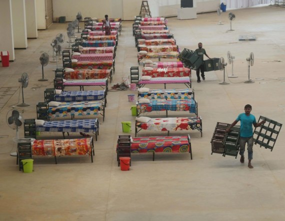 Sejumlah pekerja menyiapkan tempat tidur di sebuah pusat karantina di pinggiran Kota Agartala, India, pada 30 April 2021. (Xinhua/Str)