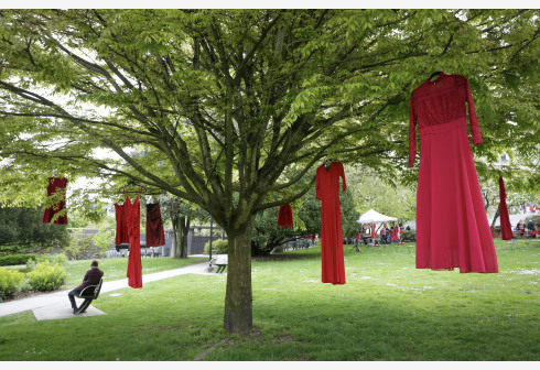 Gaun merah tampak digantung di pepohonan di luar Balai Kota di Vancouver, British Columbia, Kanada, pada 5 Mei 2021 untuk mengenang wanita dan anak perempuan pribumi yang hilang dan dibunuh.  (Xinhua/Liang Sen)