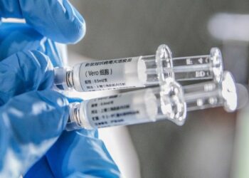Seorang staf menunjukkan sampel vaksin COVID-19 nonaktif di Sinovac Biotech Ltd., di Beijing, ibu kota China, pada 16 Maret 2020. (Xinhua/Zhang Yuwei)