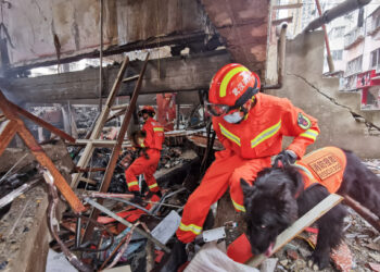 Tim penyelamat dan anjing pelacak bekerja di lokasi ledakan gas di Distrik Zhangwan di Kota Shiyan, Provinsi Hubei, China tengah, pada 13 Juni 2021. (Xinhua/Xiao Yijiu)