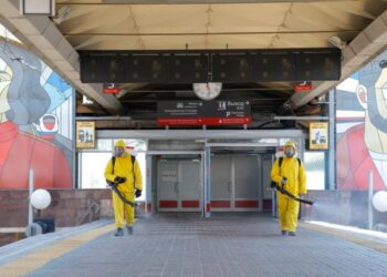 Petugas kota yang mengenakan pakaian pelindung mendisinfeksi sebuah stasiun kereta di Moskow, Rusia, pada 24 Juni 2021. (Xinhua/Alexander Zemlianichenko Jr)