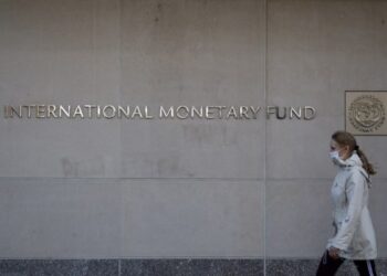 Seorang wanita berjalan melewati kantor pusat Dana Moneter Internasional (IMF) di Washington DC, Amerika Serikat, pada 30 Maret 2021. (Xinhua/Ting Shen)