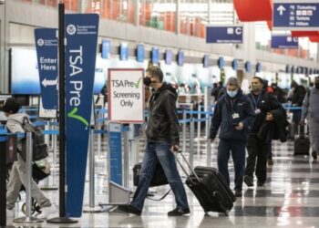 Para wisatawan yang mengenakan masker mengantre untuk pemeriksaan keamanan di Bandara Internasional O'Hare di Chicago, Amerika Serikat, pada 25 November 2020. (Xinhua/Joel Lerner)