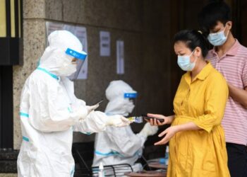 Seorang sukarelawan yang mengenakan alat pelindung diri (APD) mendata warga untuk tes asam nukleat COVID-19 di Subdistrik Baihedong di Distrik Liwan, Guangzhou, Provinsi Guangdong, China selatan, pada 12 Juni 2021. (Xinhua/Deng Hua)