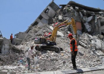 Sejumlah pekerja Palestina dan sebuah buldoser dari Mesir terlihat memindahkan reruntuhan bangunan yang hancur akibat serangan udara Israel bulan lalu di Gaza City pada 6 Juni 2021. (Xinhua/Rizek Abdeljawad)