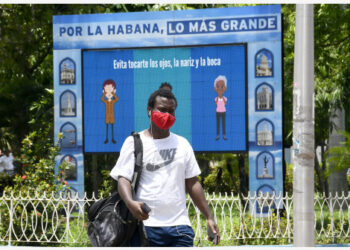 Seorang pria yang mengenakan masker melewati sebuah papan elektronik yang menunjukkan pemberitahuan pencegahan dan pengendalian epidemi di Havana, Kuba, pada 29 Juni 2021. Kuba pada Selasa (29/6) melaporkan lebih dari 3.000 kasus harian COVID-19 untuk pertama kalinya, setelah mencatat 3.080 kasus di hari itu, menambah total kasus menjadi 188.023, kata Kementerian Kesehatan Masyarakat Kuba. (Xinhua/Joaquin Hernandez)