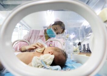Seorang perawat memberi susu kepada bayi yang baru lahir di departemen neonatologi Rumah Sakit Rakyat Rong'an di Daerah Otonom Etnis Zhuang Guangxi, China selatan, pada 1 Januari 2021. (Xinhua/Tan Kexing)