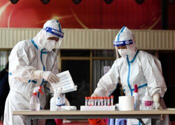 Tenaga kesehatan menyortir sampel usap (swab) untuk tes asam nukleat di Kota Ruili, Provinsi Yunnan, China barat daya, pada 5 Juli 2021.(Xinhua/Wang Guansen)