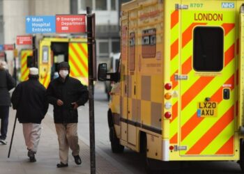 Orang-orang berjalan melewati ambulans di Rumah Sakit Royal London di London, Inggris, pada 9 April 2021. (Xinhua/Tim Ireland)