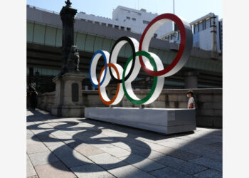Warga berjalan melewati cincin Olimpiade di Tokyo, Jepang, pada 22 Juli 2021. Upacara pembukaan Olimpiade Tokyo 2020 akan digelar pada Jumat (23/7). (Xinhua)