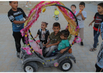 Anak-anak bermain mobil mainan hias di Kota Beit Hanoun, Jalur Gaza Utara, saat libur Hari Raya Idul Adha pada 22 Juli 2021. (Xinhua)