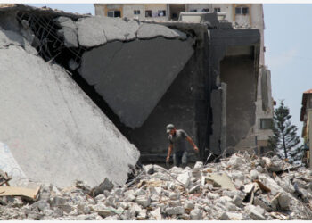 Seorang pria Palestina memeriksa reruntuhan bangunan yang hancur akibat serangan udara Israel di Gaza City pada 26 Juli 2021. (Xinhua/Rizek Abdeljawad)