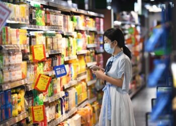 Seorang konsumen memilih produk minuman di sebuah toserba di Guiyang, Provinsi Guizhou, China barat daya, pada 16 September 2020. (Xinhua/Zhao Song)