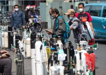 Orang-orang mengantre untuk mengisi ulang tabung oksigen mereka di kawasan Manggarai, Jakarta, pada 5 Juli 2021. (Xinhua/Veri Sanovri)