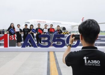 Sejumlah staf berpose untuk foto bersama di depan pesawat Airbus A350 yang dikirim ke China Eastern Airlines di Pusat Penyelesaian dan Pengiriman Pesawat Berbadan Lebar Airbus Tianjin di Tianjin, China utara, pada 21 Juli 2021. (Xinhua/Zhang Yuwei)