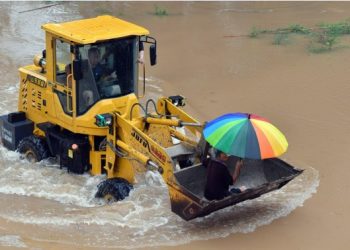 Beberapa petugas evakuasi mengendarai traktor untuk membantu penduduk setempat mengungsi dari Desa Huangzhuang di wilayah Weihui, Kota Xinxiang, Provinsi Henan, China tengah, pada 22 Juli 2021. (Xinhua/Li Jianan)