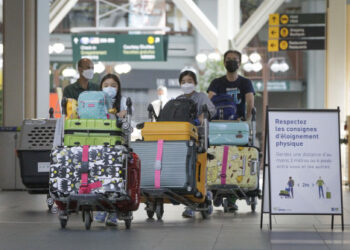 Beberapa pelancong yang mengenakan masker terlihat di Bandar Udara Internasional Vancouver di Richmond, British Columbia, Kanada, pada 5 Juli 2021. Mulai Senin (5/7), warga dan penduduk tetap Kanada yang sudah menerima "vaksinasi penuh" dapat memasuki negara itu tanpa harus menjalani karantina wajib. (Xinhua/Liang Sen)