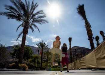 Turis berhenti untuk foto cepat patung Forever Marilyn di tengah suhu yang melonjak minggu ini di Palm Springs. (Times)