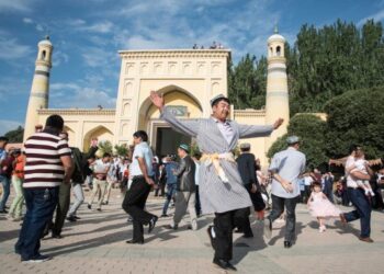 Warga Muslim menari di depan Masjid Id Kah di Kashgar, Daerah Otonom Uighur Xinjiang, China barat laut, pada 6 Juli 2016. (Xinhua/Bu Duomen)