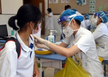 Tenaga kesehatan menyuntikkan dosis vaksin COVID-19 kepada seorang siswi di Beijing, ibu kota China, pada 21 Agustus 2021. (Xinhua/Ren Chao)