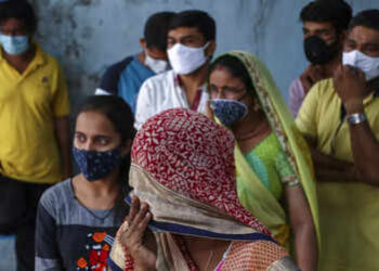 Warga India menggunakan masker saat di luar ruangan. /ist