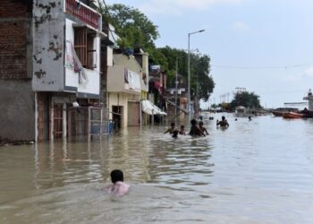 Warga menerjang jalanan yang banjir akibat meluapnya Sungai Gangga pascahujan monsun di Distrik Prayagraj, Negara Bagian Uttar Pradesh, India utara, pada 6 Agustus 2021. (Xinhua/Str)