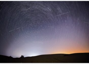 Foto montase yang diabadikan pada 13 Agustus 2021 ini menunjukkan langit malam saat Hujan Meteor Perseid di atas zona demonstrasi ekologis Engebei di Gurun Kubuqi, Daerah Otonom Mongolia Dalam, China utara. (Xinhua/Lian Zhen)