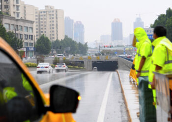 Para petugas bekerja di depan sebuah terowongan di Zhengzhou, ibu kota Provinsi Henan, di China tengah pada 22 Agustus 2021. (Xinhua/Hao Yuan)