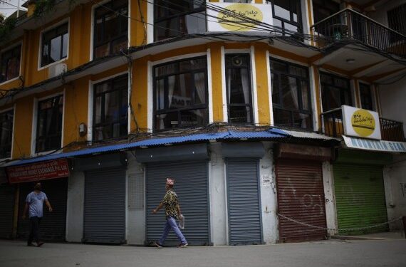 Orang-orang berjalan melewati toko-toko yang tutup di Thamel, sebuah pusat pariwisata di ibu kota Nepal, Kathmandu, pada 17 Juni 2021. (Xinhua/Sulav Shrestha)