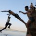 Anak-anak melompat ke Sungai Nil untuk mendinginkan diri di tengah gelombang panas di Provinsi Qalyubia, Mesir, pada 6 Agustus 2021. Gelombang panas melanda Mesir selama lebih dari sepekan, dengan suhu mencapai di atas 40 derajat Celsius pada siang hari. (Xinhua/Ahmed Gomaa)