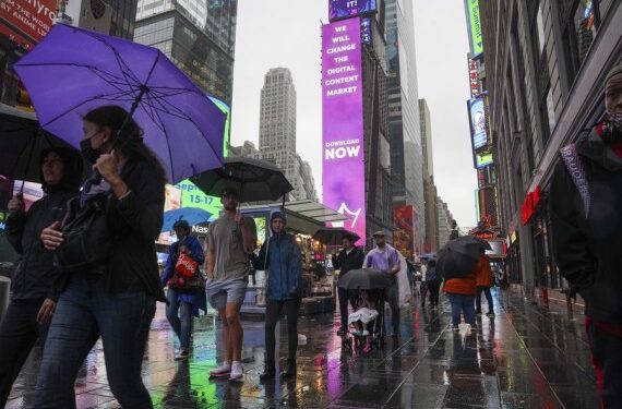 Para pejalan kaki berjalan di tengah hujan yang dipicu oleh Badai Tropis Henri di Times Square di New York, Amerika Serikat, pada 22 Agustus 2021. (Xinhua/Wang Ying)