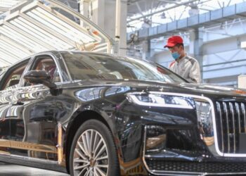 Foto yang diabadikan pada 23 September 2020 ini menunjukkan seorang pekerja sedang memeriksa kendaraan di lini perakitan umum Hongqi, merek sedan terkemuka First Automotive Works (FAW) Group Co. Ltd., di Changchun, Provinsi Jilin, China timur laut. (Xinhua/Zhang Nan)
