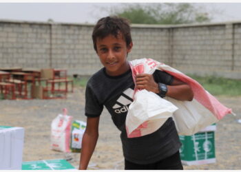 Seorang anak laki-laki membawa tas berisi donasi kotak makanan di sebuah pusat bantuan di Provinsi Hajjah, Yaman utara, pada 15 Agustus 2021. (Xinhua/Mohammed Al-Wafi)