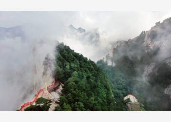 Foto dari udara yang diabadikan pada 14 Agustus 2021 ini menunjukkan Gunung Huashan yang diselimuti kabut di Kota Weinan, Provinsi Shaanxi, China barat laut. (Xinhua/Tao Ming)