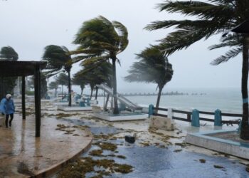 Seseorang berjalan di tengah hujan yang disebabkan oleh badai Grace di Puerto Morelos, Quintana Roo, Meksiko, pada 19 Agustus 2021. (Xinhua/Israel Rosas)