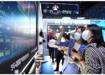 Seorang staf (kiri) memperkenalkan aplikasi teknologi 5G kepada pengunjung di Smart China Expo di Chongqing, China barat daya, pada 23 Agustus 2021. (Xinhua/Tang Yi)
