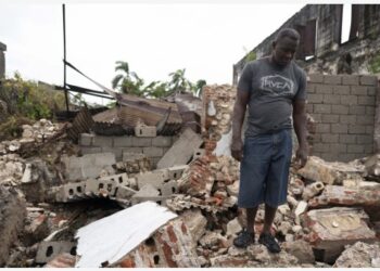 Seorang pria berdiri di atas reruntuhan rumah yang hancur pascagempa bumi di Les Cayes, Haiti, pada 17 Agustus 2021. (Xinhua/David de la Paz)