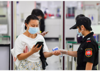 Seorang penumpang diukur suhu tubuhnya di stasiun metro Machang di Changsha, Provinsi Hunan, China tengah, pada 2 Agustus 2021. (Xinhua/Chen Zeguo)