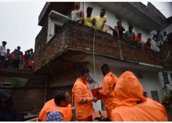 Anggota Pasukan Tanggap Bencana Nasional (National Disaster Response Force/NDRF) India mendistribusikan bantuan kepada warga yang terdampak banjir yang rumahnya masih terendam air setelah Sungai Gangga meluap akibat hujan monsun di Distrik Prayagraj, Negara Bagian Uttar Pradesh, India utara, 11 Agustus 2021. (Xinhua/Str)