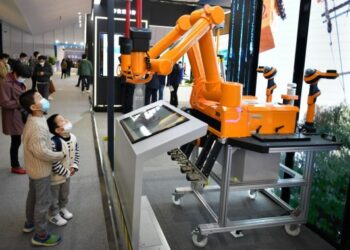 Pengunjung mengamati sebuah robot di stan State Grid China dalam pameran bertajuk Light of Internet Expo di Konferensi Internet Dunia 2020 yang diadakan di Wuzhen, Provinsi Zhejiang, China timur, pada 22 November 2020. (Xinhua/Li Xin)