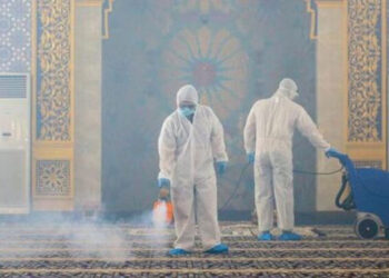Petugas mengenakan APD melakukan semprotan desinfektan di sebuah masjid di Bandar Seri Begawan, Brunei. /AFP